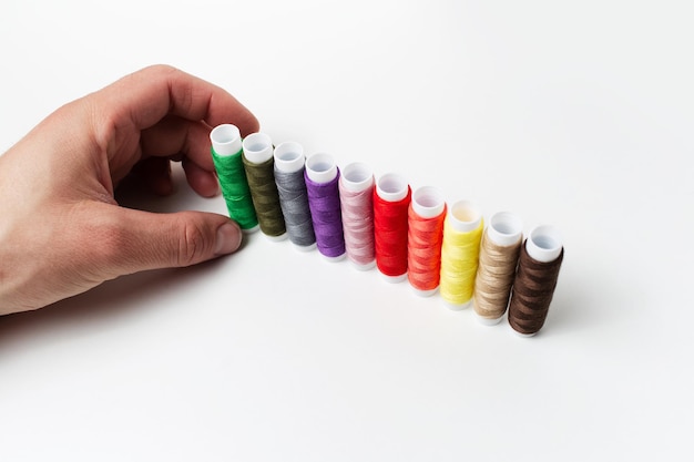Manos bordando hilo colorido